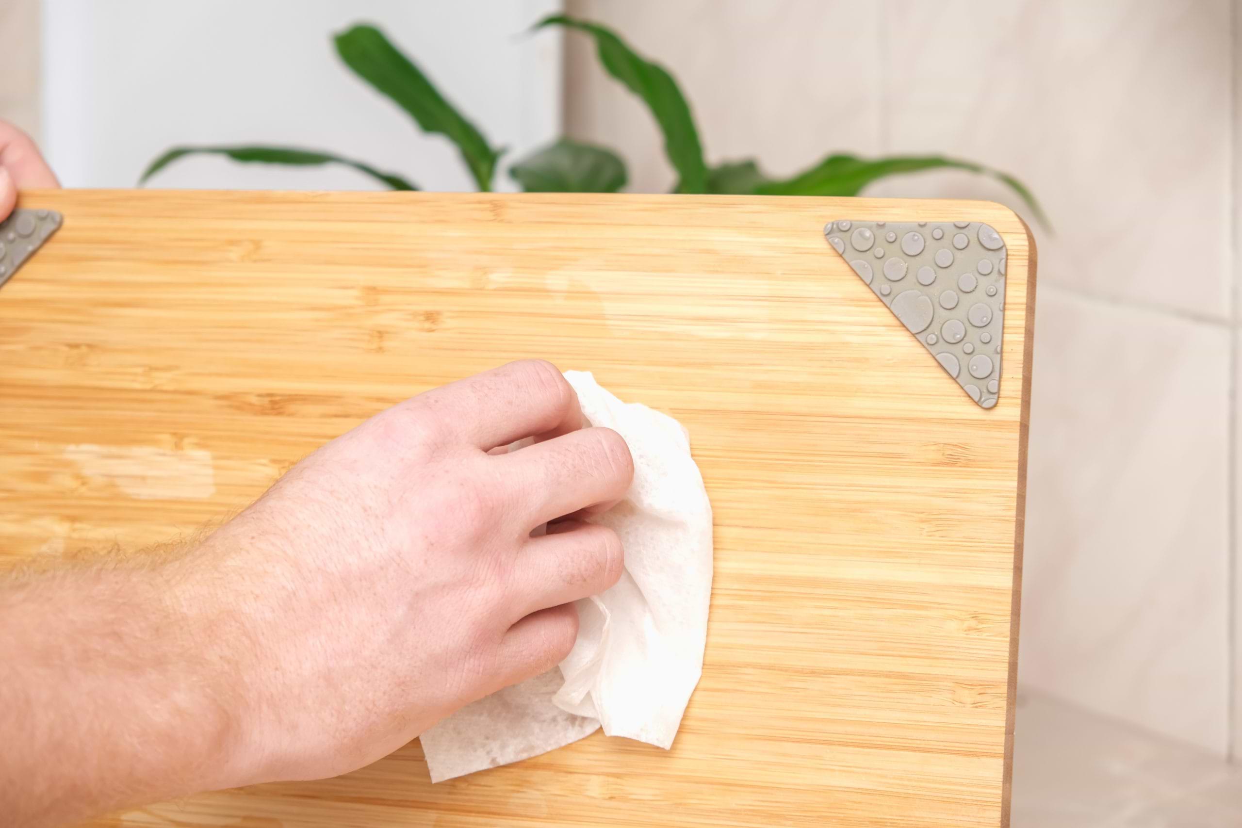A,Man,Wipes,A,Bamboo,Cutting,Board,With,A,White cubiertos y ensalada