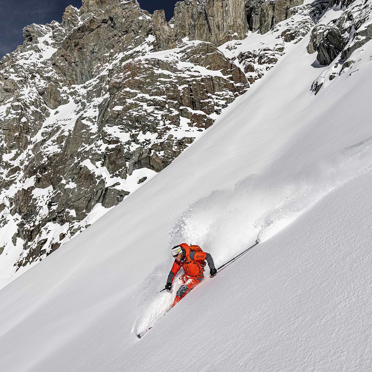 Mountain guide Jonas Swensson with a big turn on the mountain in perfect conditions. Wearing the Stellar Eq Guide 2.0 System in Orange.