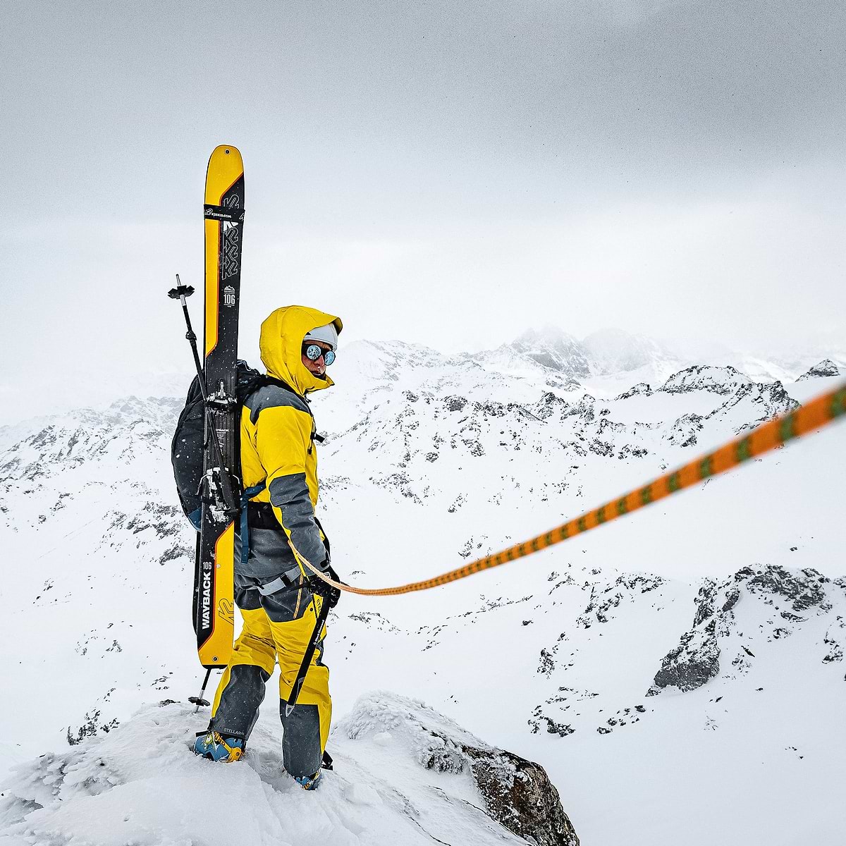 Baptiste Sjöström climbing a ridge, getting ready for a line in Verbier, Switzerland. He is wearing the full Stellar Equipment mens Guide Shell 2.0 System in yellow. The photo was taken by Christoffer Sjöström.