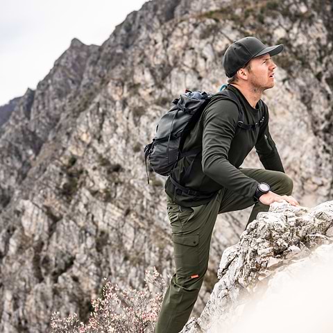 A hiker needs to climb the last part to the summit of a mountain. Wearing the Stellar Equipment Light Mid Sweater in Dark Green.