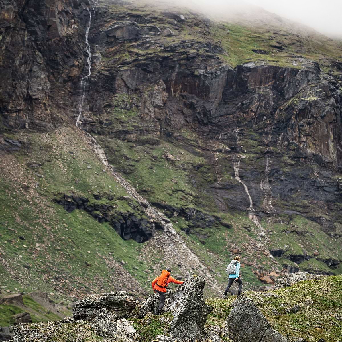 Two hikers are exploring a valley in Björkliden, surrounded by mountains. Wearing the Stellar EQ Ultralight Shell jackets.