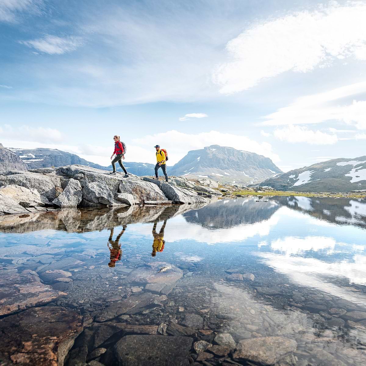Two hikers are exploring a valley in Björkliden, surrounded by mountains. Wearing the Stellar EQ Ultralight Shell jackets.