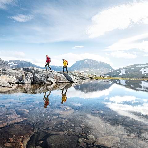 Two hikers are exploring a valley in Björkliden, surrounded by mountains. Wearing the Stellar EQ Ultralight Shell jackets.