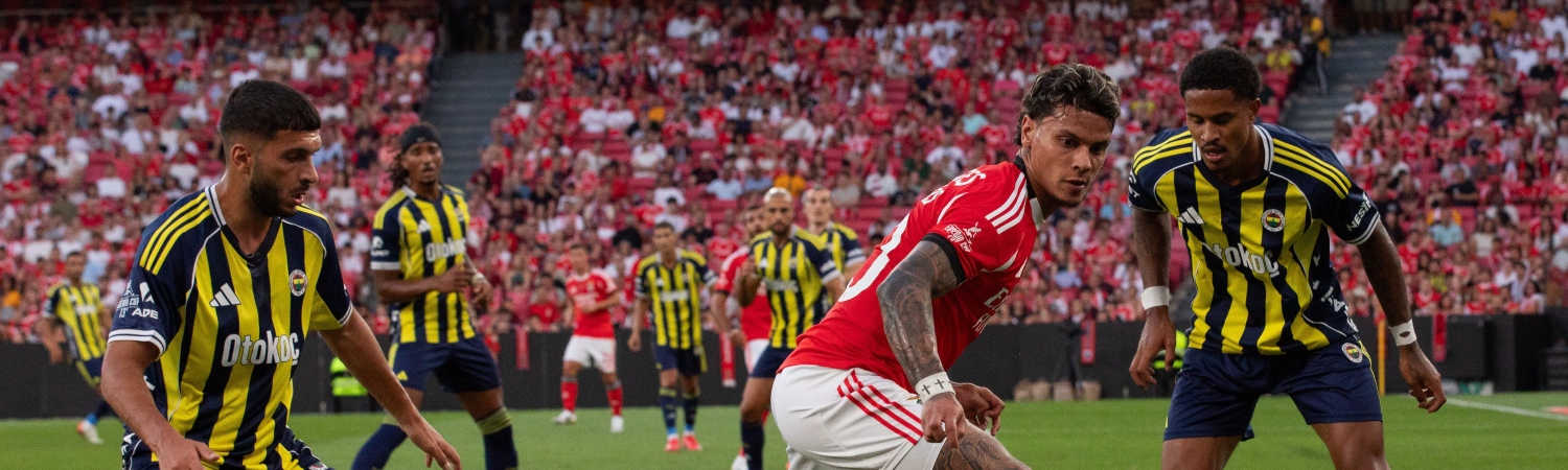Imagen de Richard Ríos con el uniforme del Benfica durante un partido, destacando su estilo de regate y dominio del balón en el centro del campo.