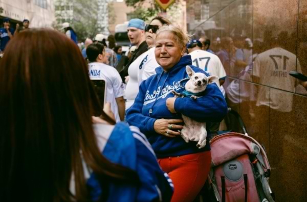 fanática de los dodgers carga a su perrito chihuahua en una fila para ver el partido de LA Dodgers