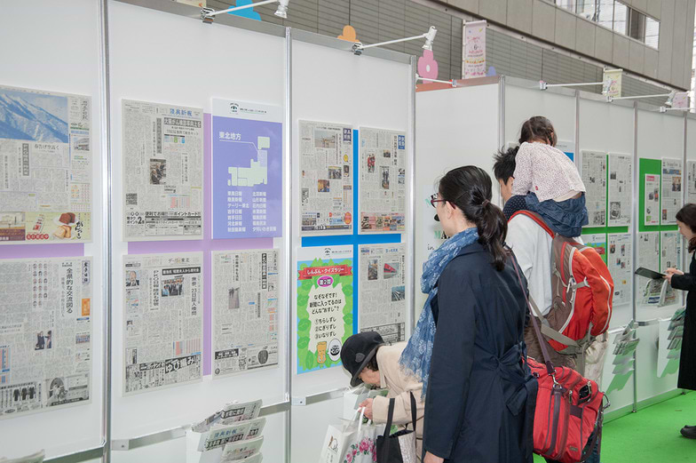 各紙を比べながらじっくり試読する来場者