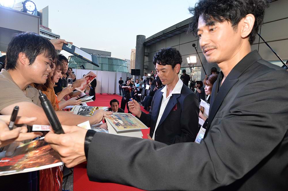 会場に集まったファンと交流する妻夫木聡さん（中央）と永山瑛太さん（右）